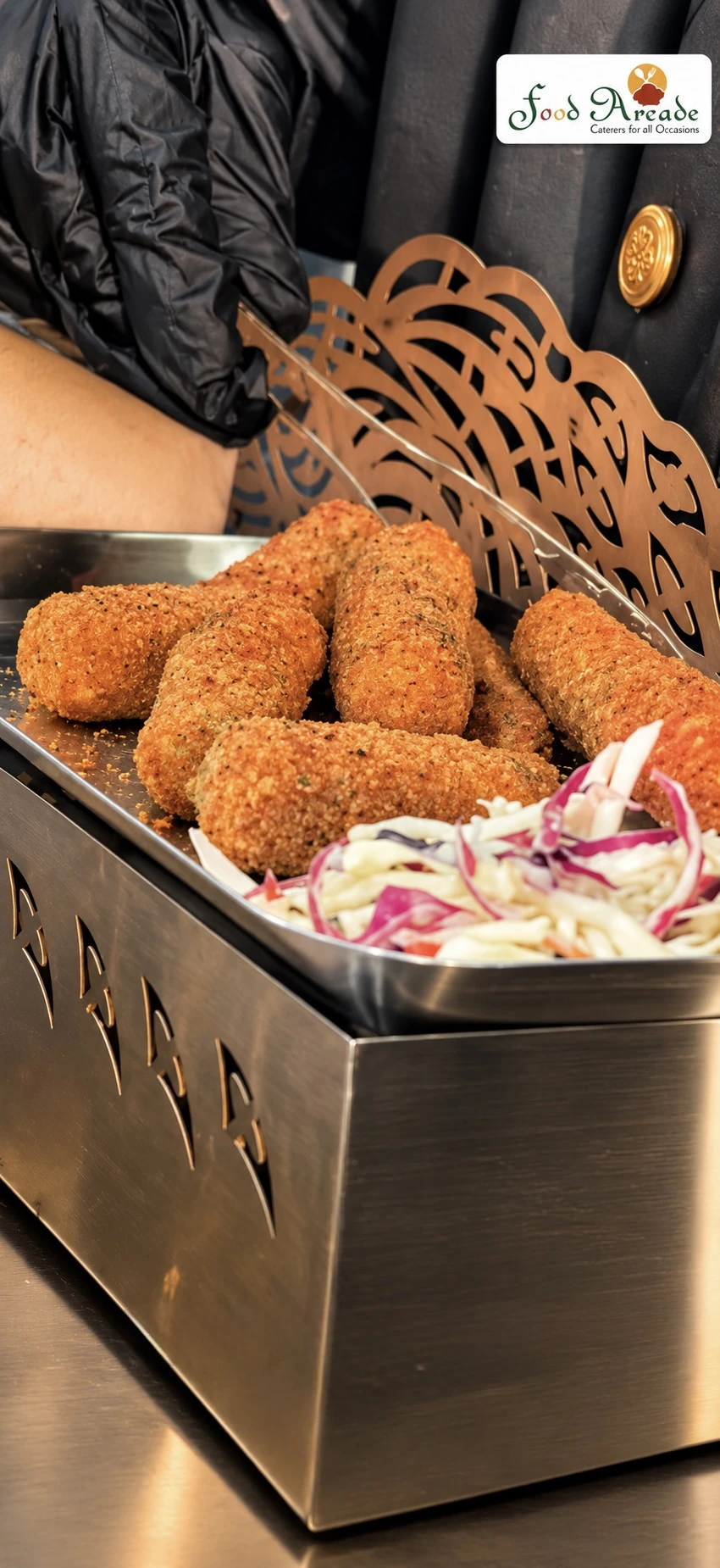 Golden crumbed croquettes with slaw on a steel tray with a decorative cut-metal stand